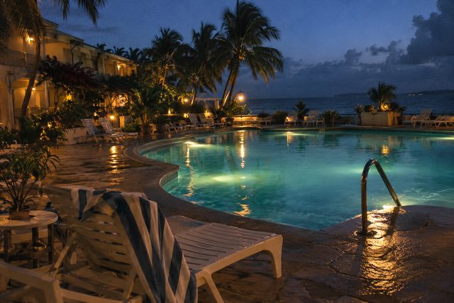The last evening: empty loungers, a forgotten towel, and the hotel pool at dusk.