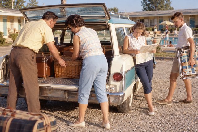 A roadside motel stop with a packed station wagon and one suitcase too many.